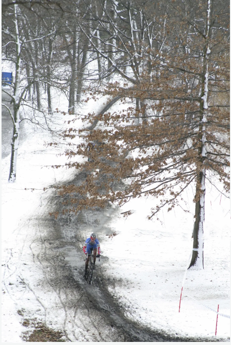Cyclist on a SAVA carbon bike riding a muddy trail in snowy winter forest