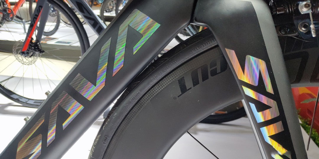 Close-up of SAVA carbon bike frame and wheel with holographic SAVA logo