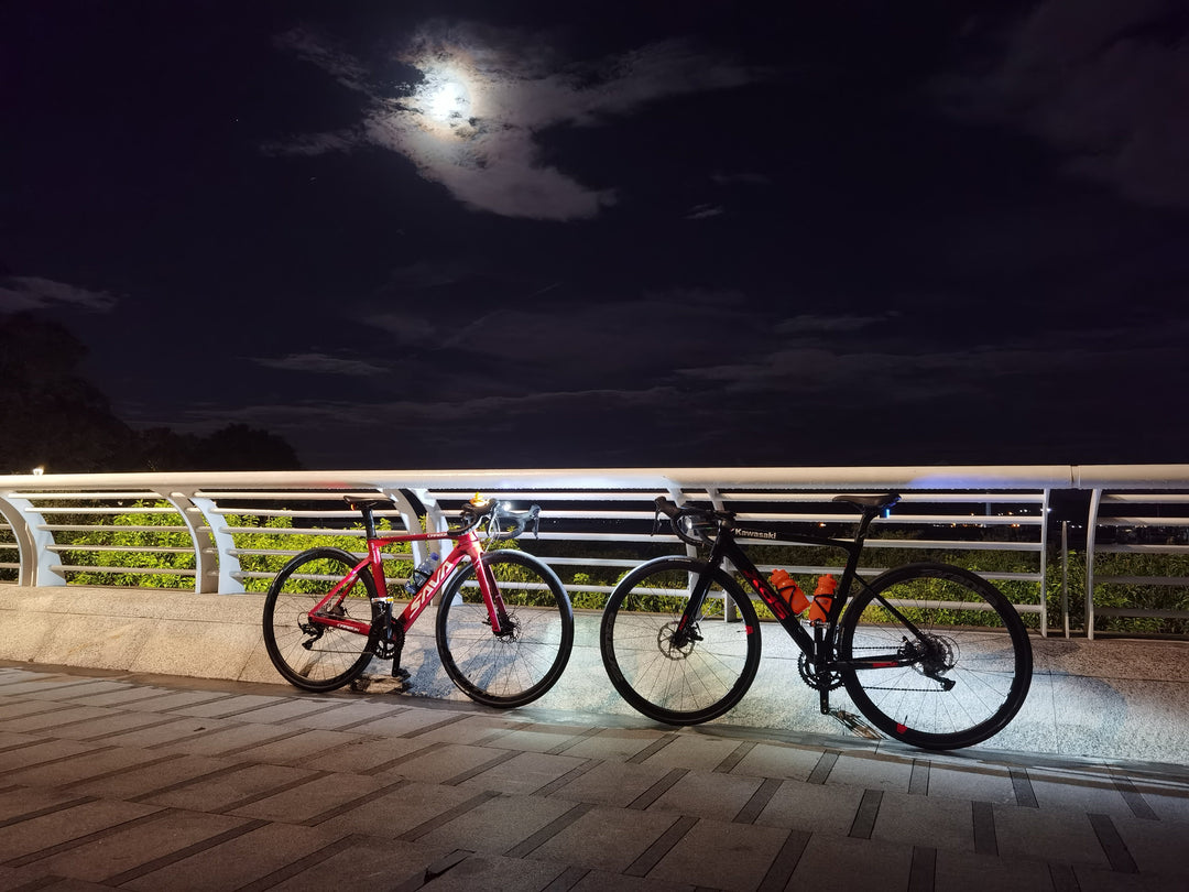 SAVA carbon road bikes parked on a bridge at night under the moonlight.