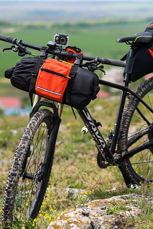 SAVA carbon mountain bike with front pack on rocky landscape, outdoor adventure scene