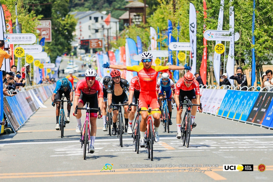Cyclists racing toward finish line in a UCI Asia Tour event using SAVA carbon road bikes