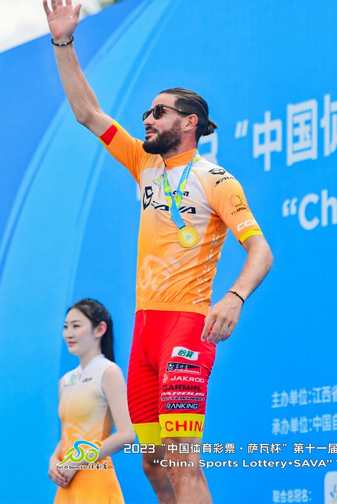 Cyclist in SAVA cycling jersey celebrates on podium at China Sports Lottery event