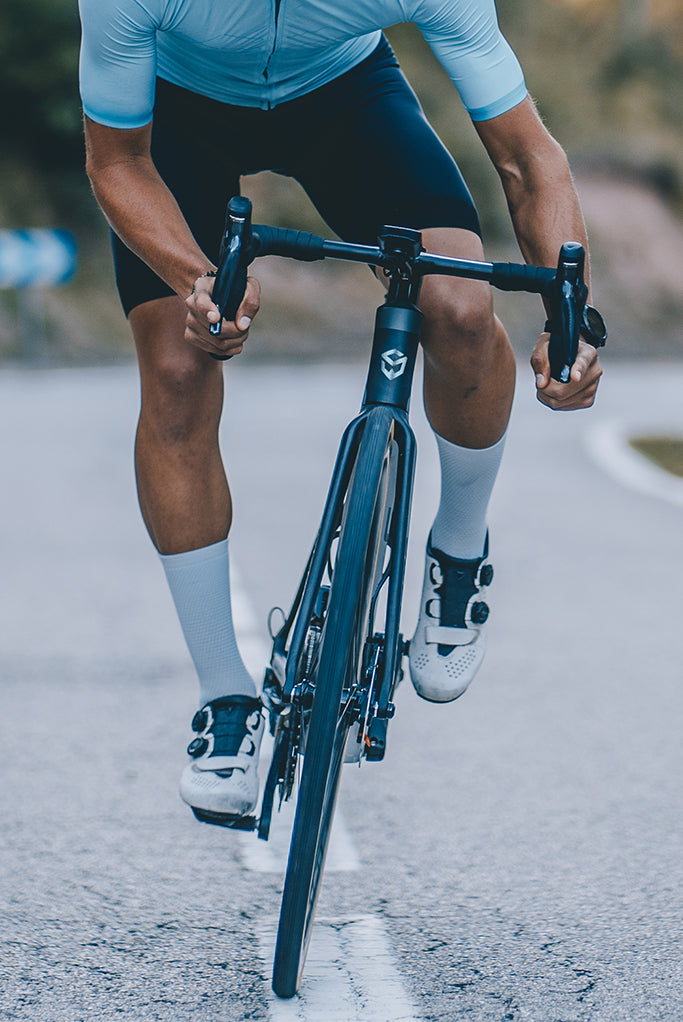 Cyclist riding SAVA carbon road bike on pavement, showcasing innovative bike design.