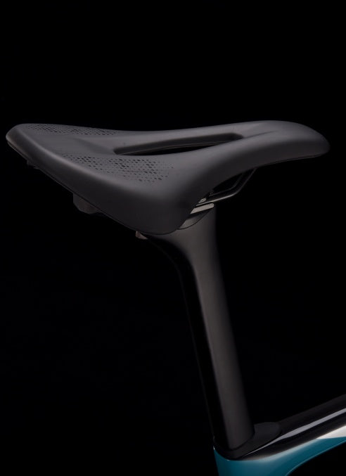 Close-up of SAVA carbon bike seatpost and saddle against black background