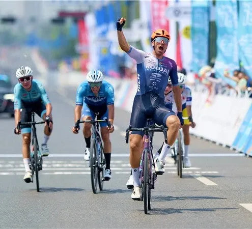 Cyclist celebrates winning road race on SAVA Carbon bike, crossing finish line ahead of competitors